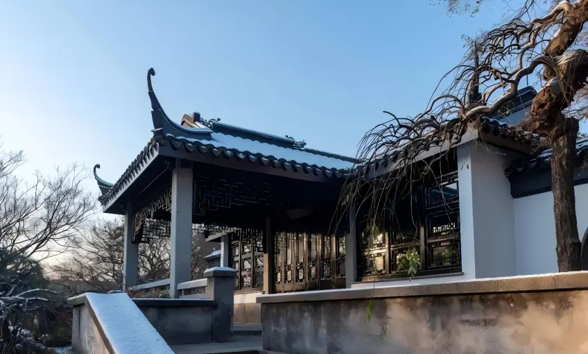 无锡荣氏梅园雪景白墙飞檐传统亭台与枯枝